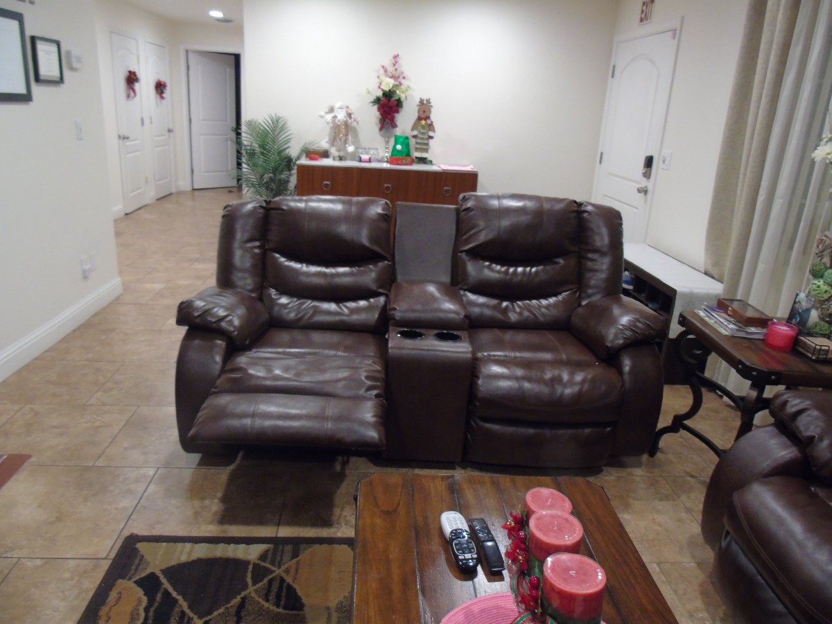 A cozy living room featuring a brown leather reclining sofa with a coffee table in the foreground.