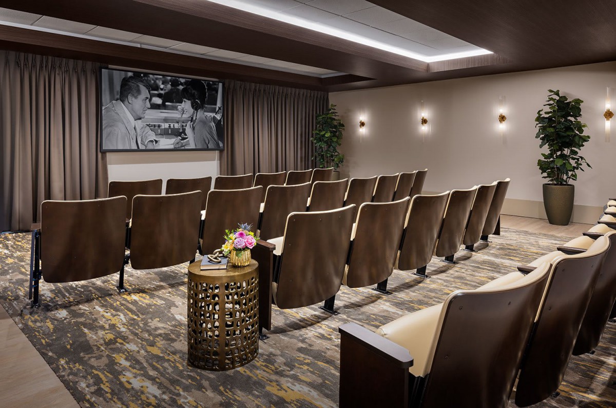 A cozy theater room with rows of comfortable seating and a large projection screen.
