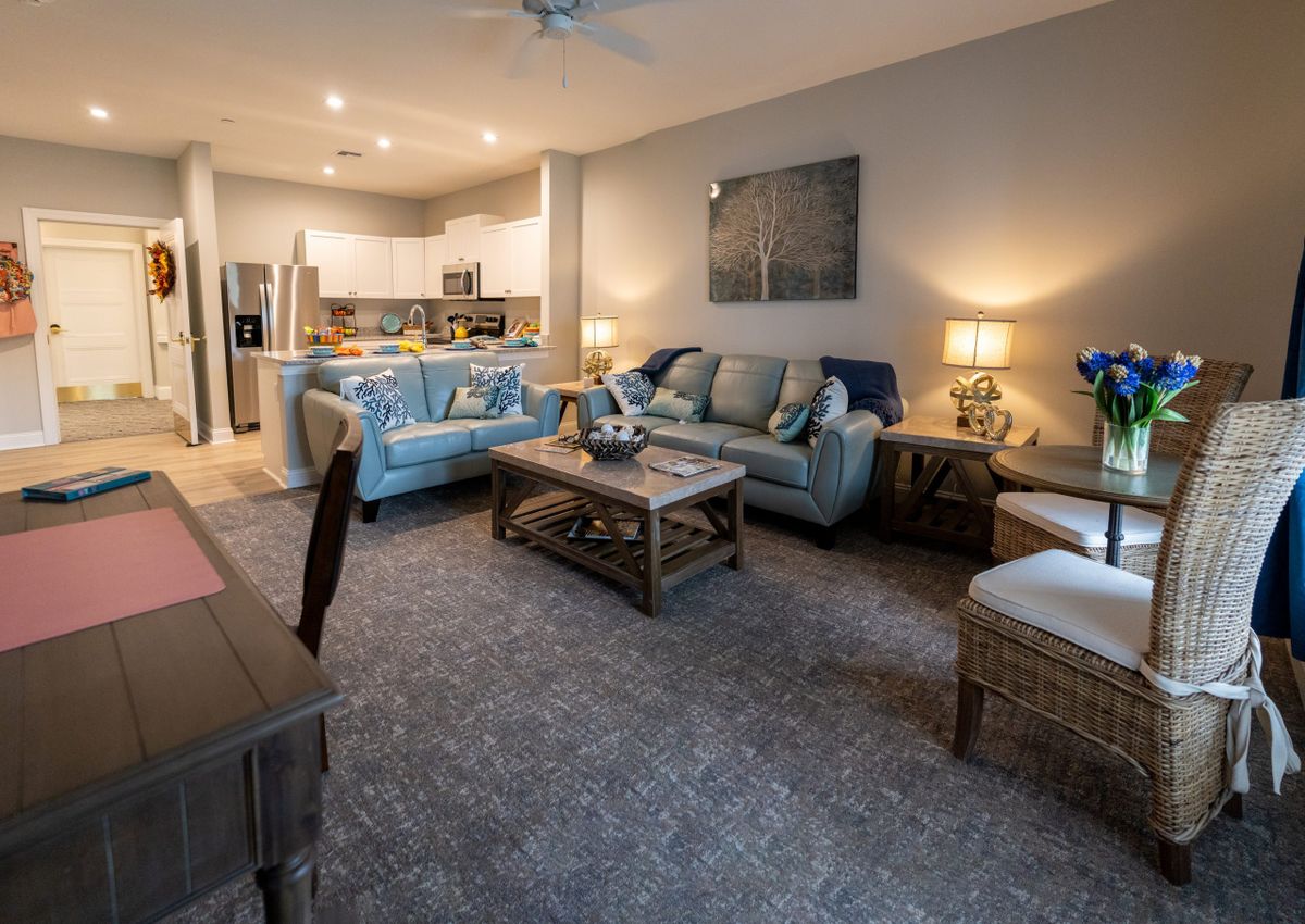 A modern, open-concept living room with a cozy seating area and adjoining kitchen.