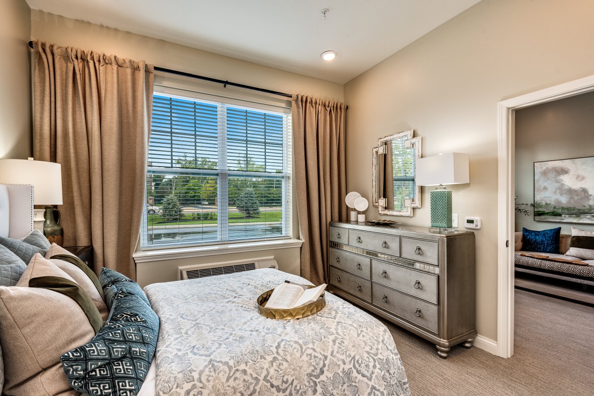 A tastefully decorated bedroom with a large window and elegant furnishings.