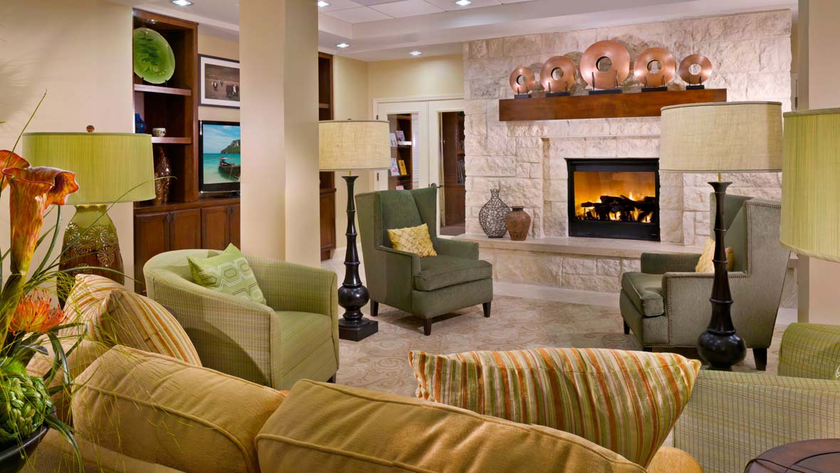 A cozy living room featuring comfortable seating and a warm fireplace.