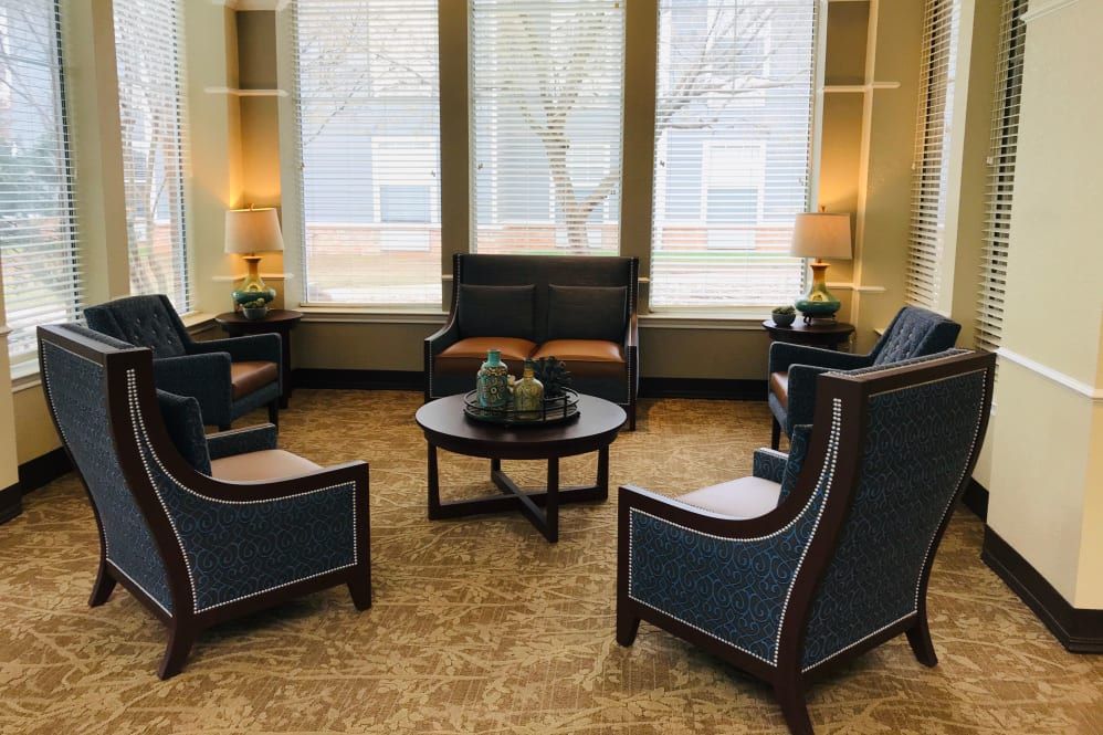 A cozy seating area with comfortable chairs, a sofa, and warm lighting.