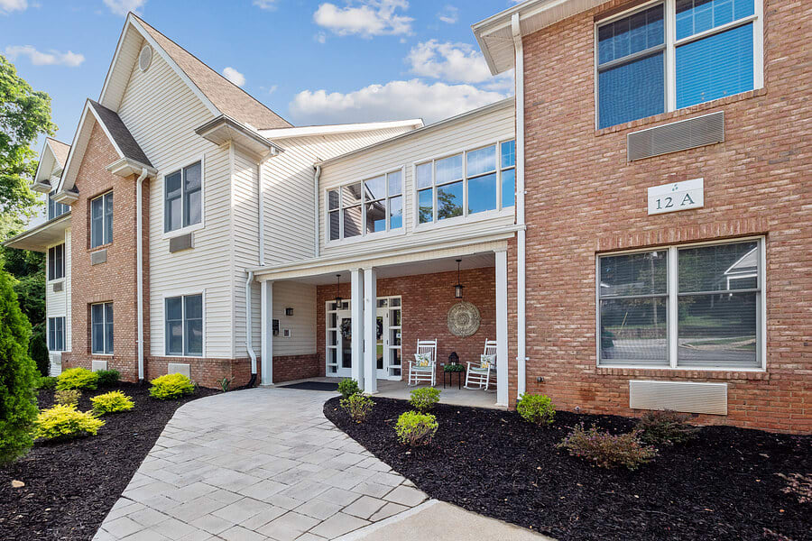 A modern residential building entrance with well-maintained landscaping.