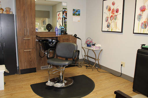 A modern hair salon featuring a stylish styling chair and decorative wall art.