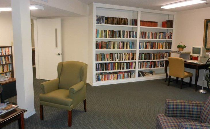A cozy reading area with a bookshelf filled with books and a comfortable chair.