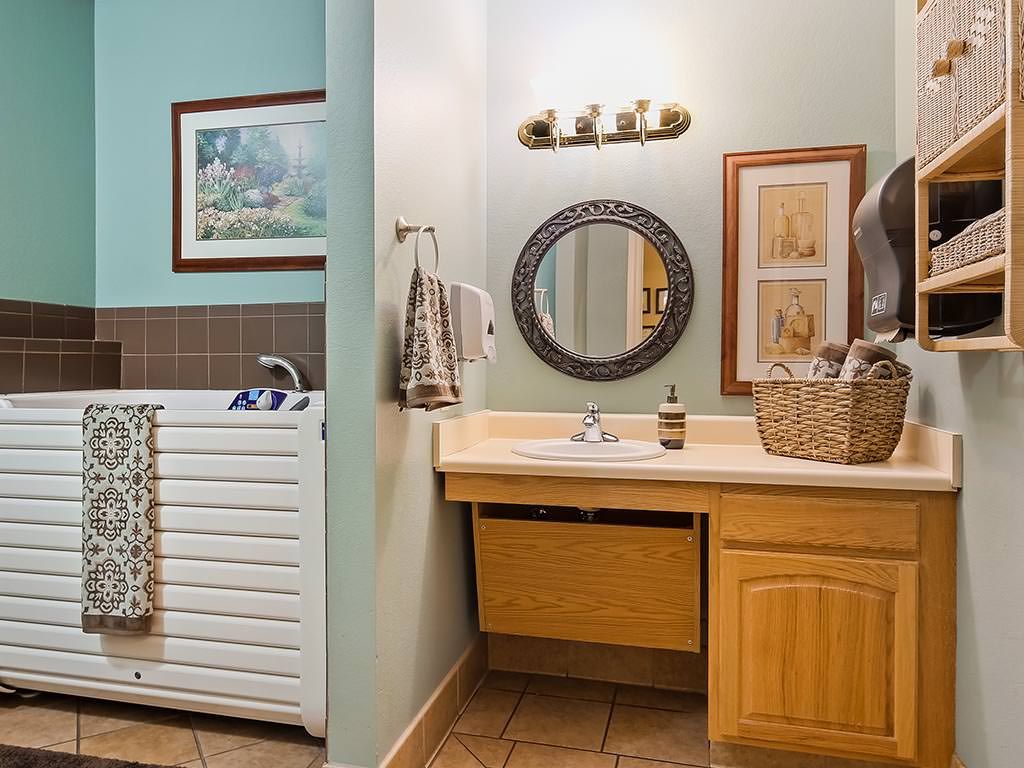 A well-decorated bathroom vanity with a round mirror and wall art.