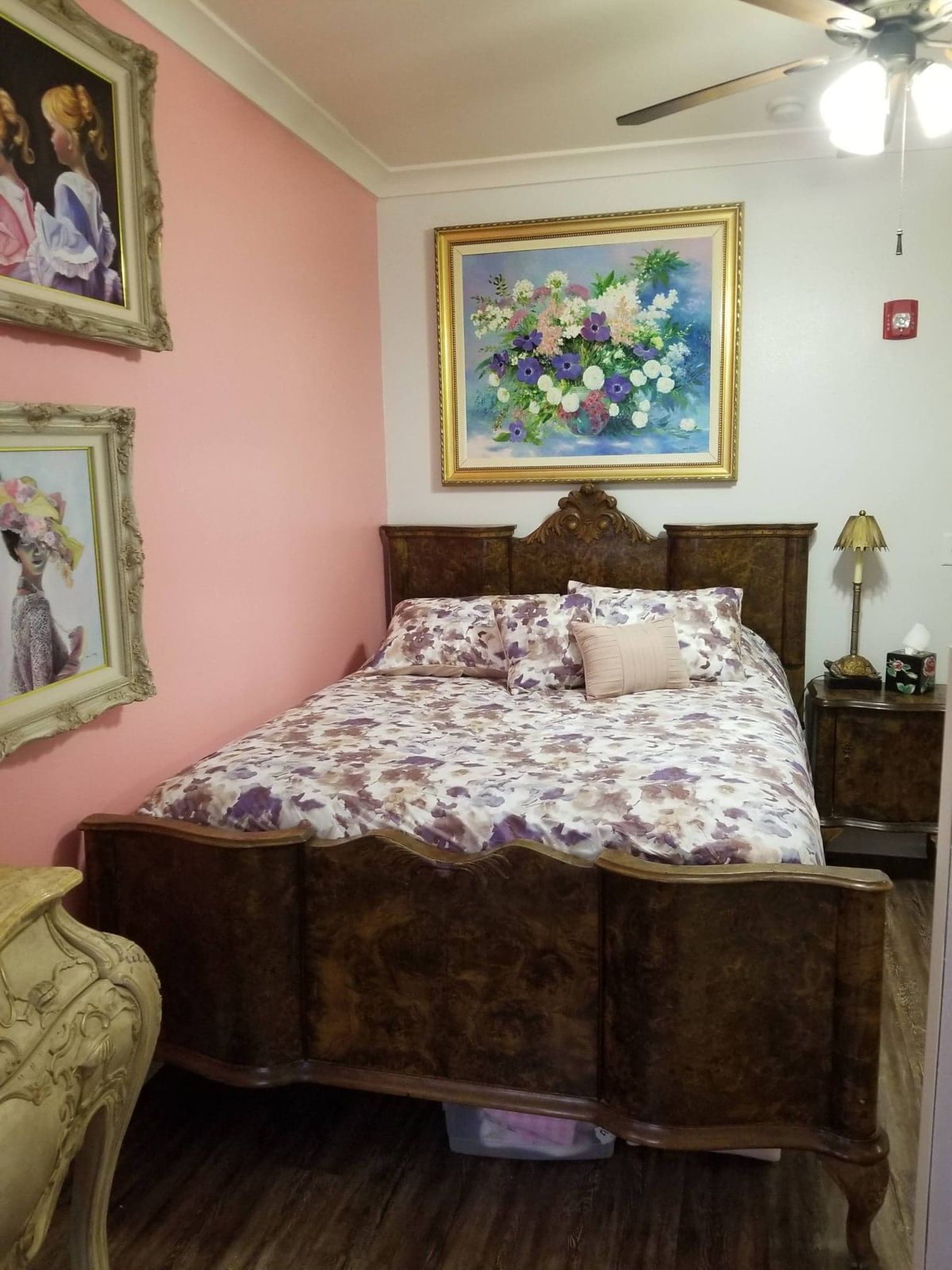 A cozy bedroom with vintage-style furniture and floral decor.