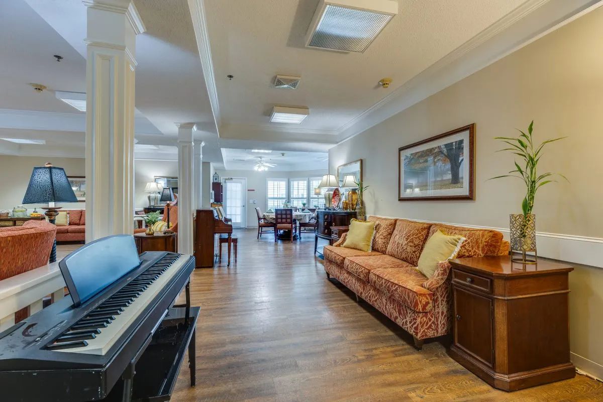 A spacious living room with a piano, sofa, and stylish decor.