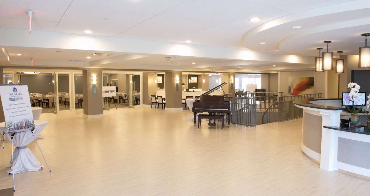 A modern and spacious lobby featuring a grand piano with ample seating.