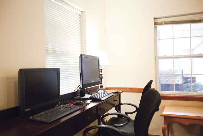 A tidy home office with a dual monitor computer setup.