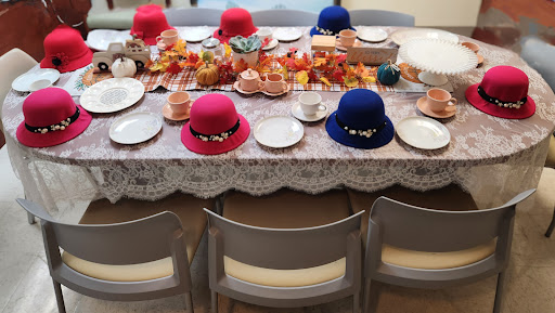 A vibrant autumn-themed table setting adorned with colorful hats and seasonal decorations.