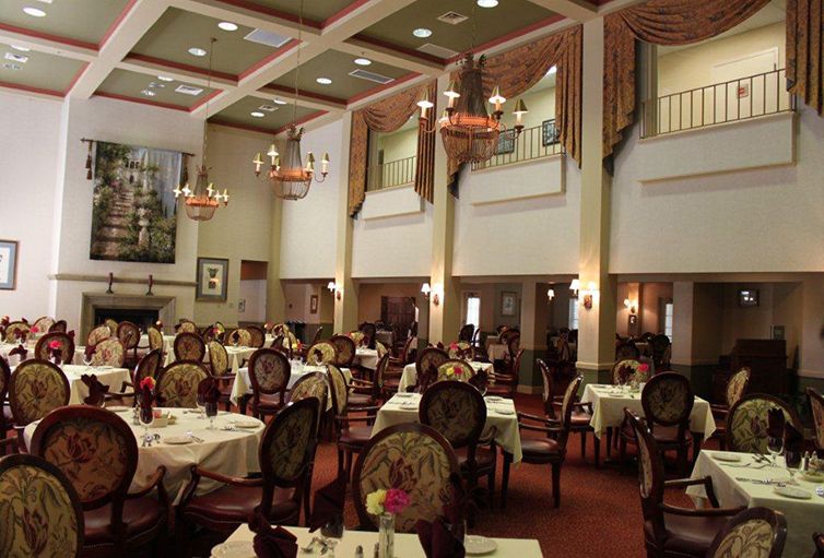 An elegant restaurant dining area with ornate furnishings and chandeliers.