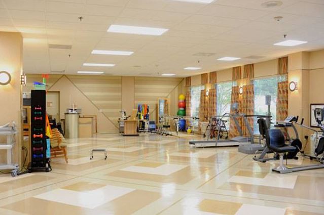 A spacious gym with various exercise equipment and a bright interior.