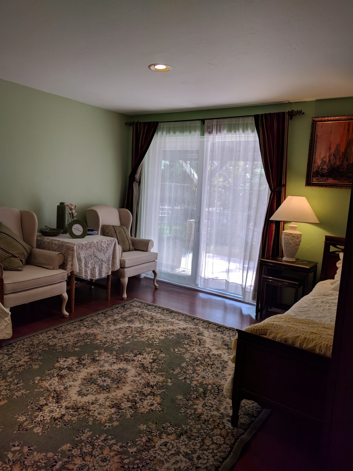 A cozy living room with two armchairs, a small coffee table, and a large window with curtains.