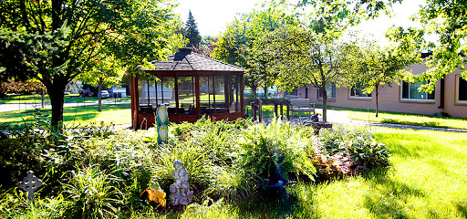 A serene garden featuring a gazebo surrounded by lush greenery.