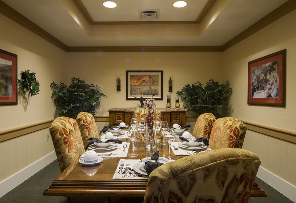A formally set dining room table with elegant chairs and decor.
