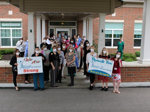 A group of people gathered outside a building, holding signs to show support and solidarity.