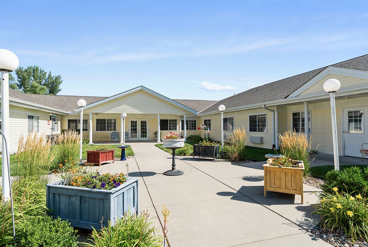 A sunny day in a well-maintained courtyard with landscaping and a pathway.