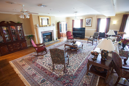 A spacious living room featuring comfortable seating, a cozy fireplace, and a vibrant rug.