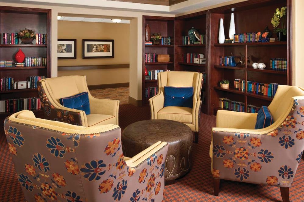 A cozy library seating area with armchairs and bookshelves.