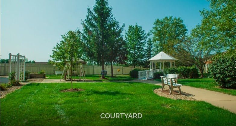 A beautiful courtyard featuring a gazebo surrounded by lush greenery and trees.