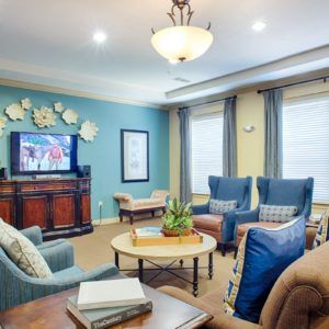 A well-furnished living room with comfortable seating, a television, and stylish decor elements.