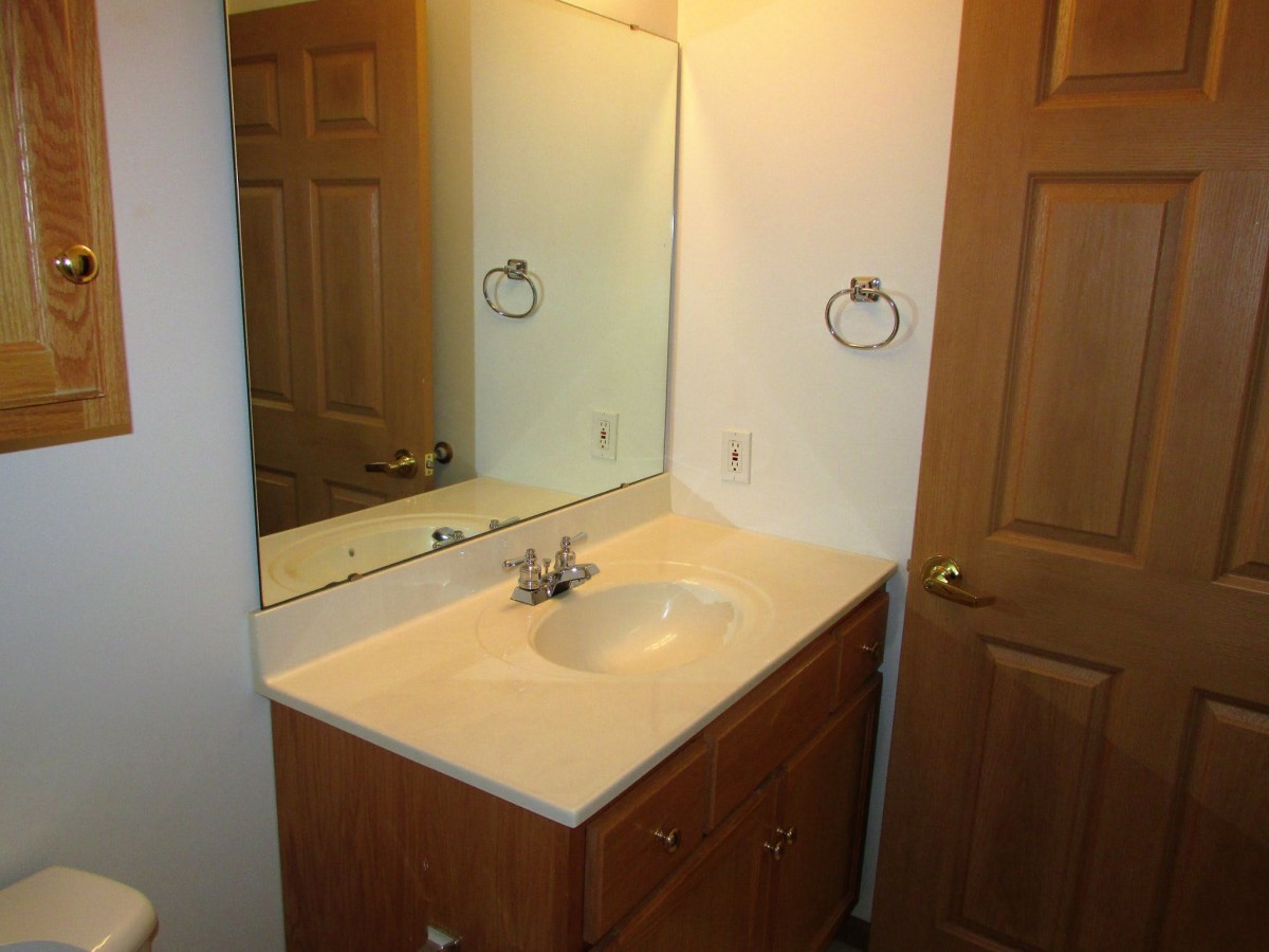 A bathroom scene with a vanity, sink, and large mirror.