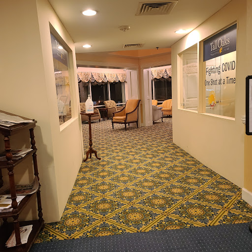 A cozy hallway leading to a seating area, featuring patterned carpet and warm lighting.