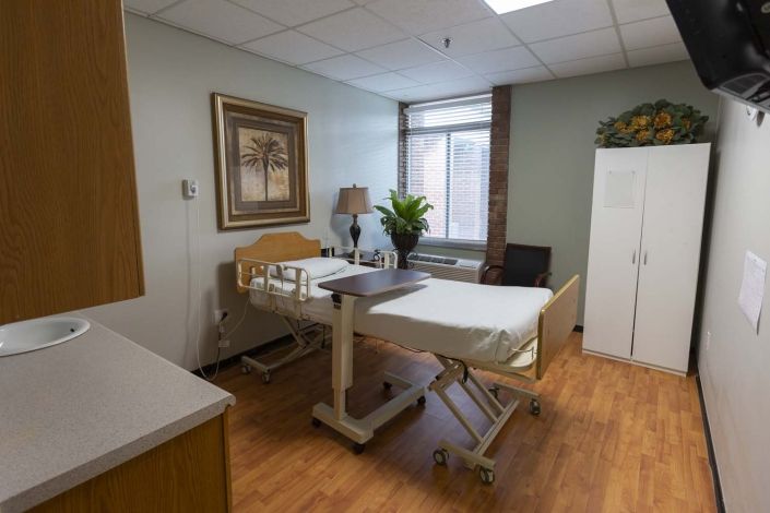 A clean and organized hospital room with a patient bed and medical equipment.