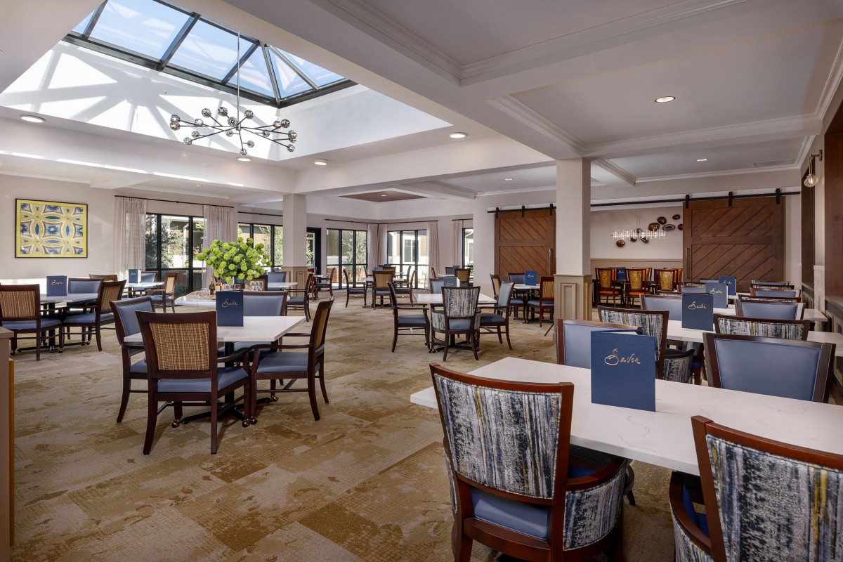 Spacious and elegantly designed restaurant dining area with skylight and comfortable seating.