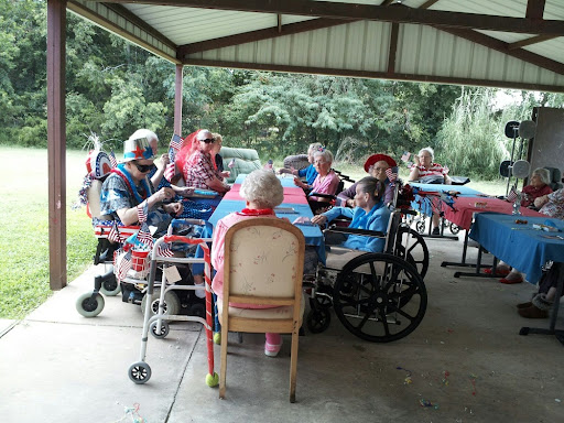 A group of elderly individuals enjoying a social gathering under a covered area.