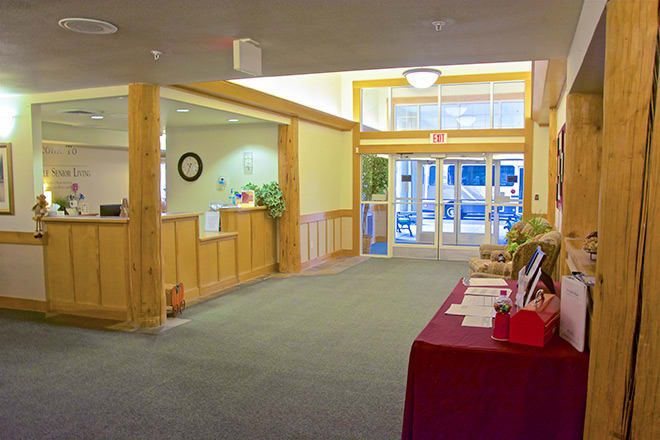 A spacious lobby with a reception desk and entrance doors.