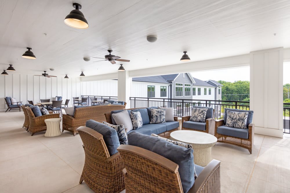 A modern outdoor patio with wicker furniture and a covered seating area.
