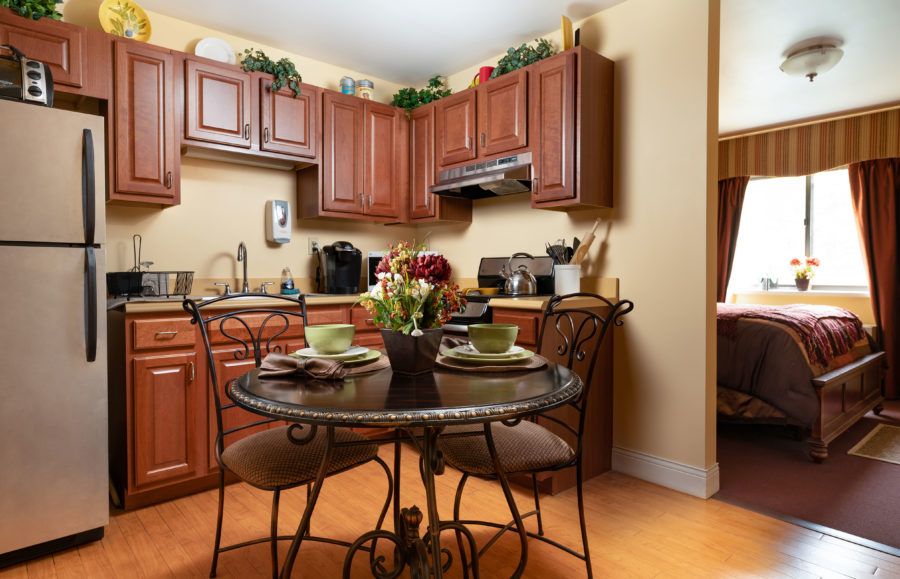 Cozy kitchen with wooden cabinets and a small dining table set for two.