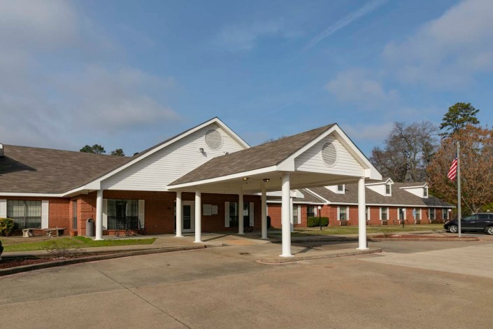 A school building with a covered entrance on a sunny day.