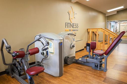 An interior view of a gym showcasing various fitness machines for strength training.
