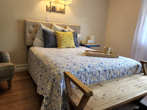 A cozy bedroom setup featuring a beautifully made bed with decorative pillows and a wooden table.