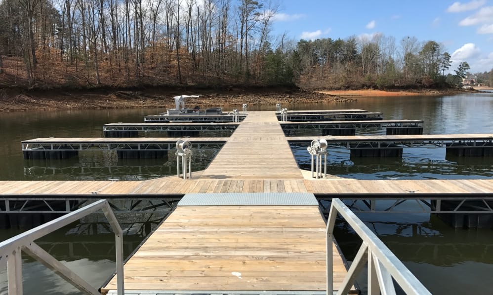 A wooden dock extending over a calm lake under a clear sky.