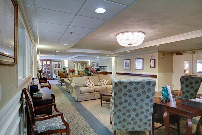 A cozy seating area in a well-lit lobby with sofas, chairs, and a chandelier.