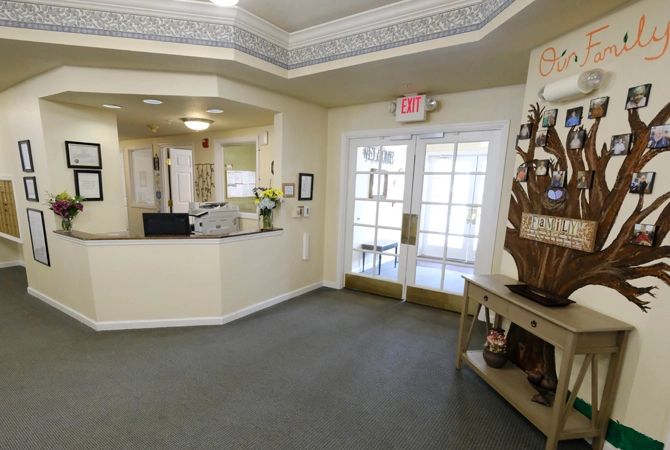 A well-lit lobby area with a reception desk, decorative elements, and a carpeted floor.