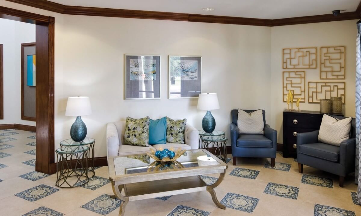 A cozy and elegantly decorated living room with a sofa, armchair, coffee table, and decorative elements.