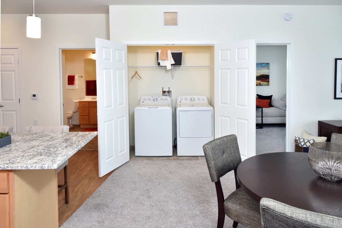 A cozy home interior featuring an open laundry area with a washer and dryer, adjacent to a dining space.