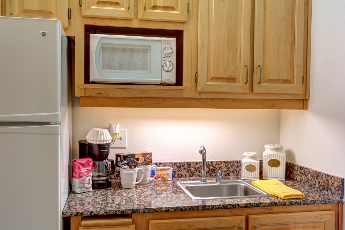 A cozy kitchen corner with a microwave and coffee maker on the countertop.