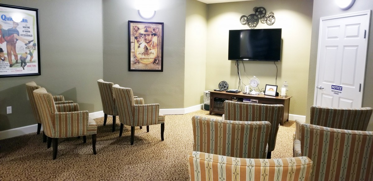 A cozy seating area with striped chairs, a wall-mounted TV, and decorative elements.