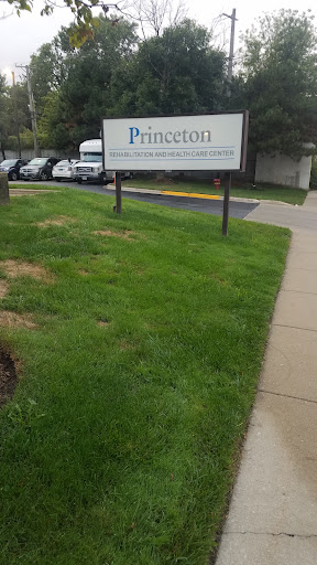 A sign for 'Princeton' located outside, surrounded by grass and a parking area.