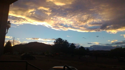 A beautiful sunset painting the sky with vibrant clouds over a mountainous landscape.