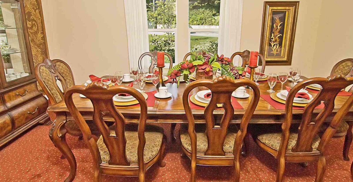 A well-set dining table with elegant wooden chairs and decorative tableware in a cozy dining room.