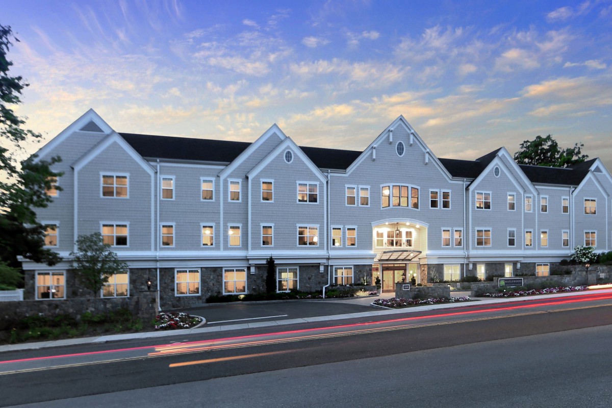 A residential building with illuminated windows at dusk.