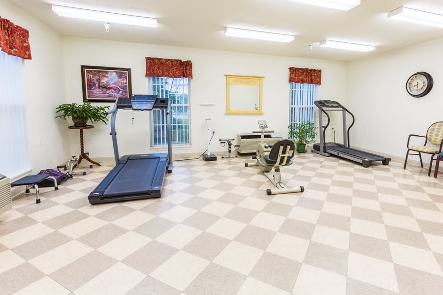 A small gym with treadmills and exercise equipment in a bright, well-lit room.