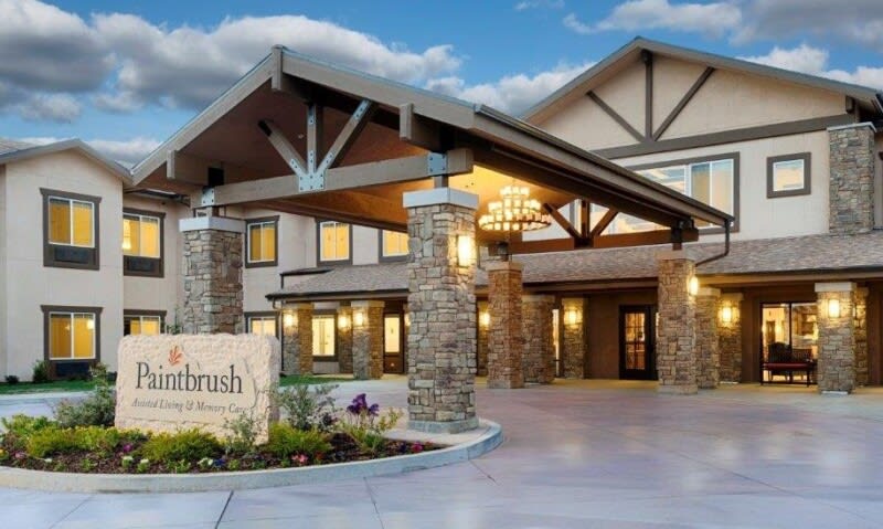 A well-lit building entrance with architectural features and landscaping.